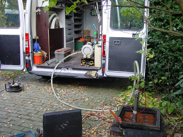 Mobiele werkwagen met meetapparatuur aangesloten op een inspectieput