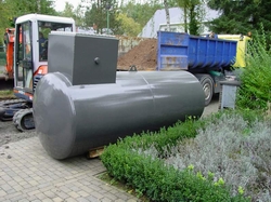 Nieuwe horizontale opslagtank op een verharde ondergrond, met bouwmachines op de achtergrond
